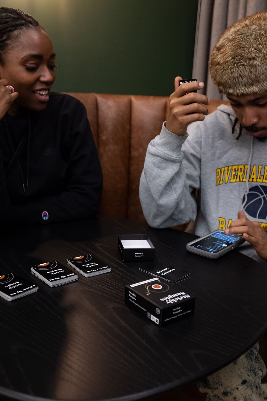 Friends playing the Strickly Samples card game at a table