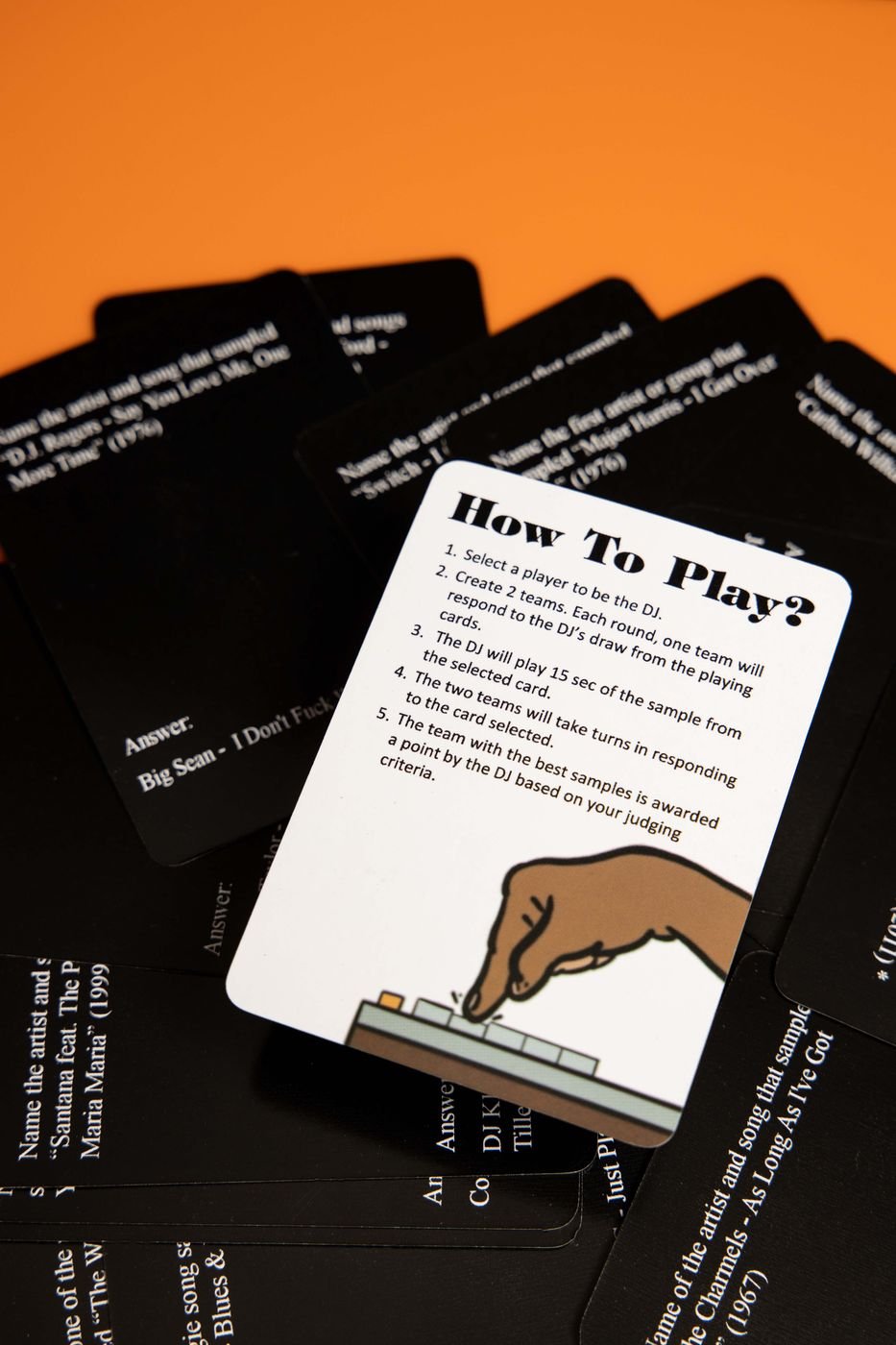 Strickly Samples trivia cards fanned on an orange backdrop with the how-to-play card